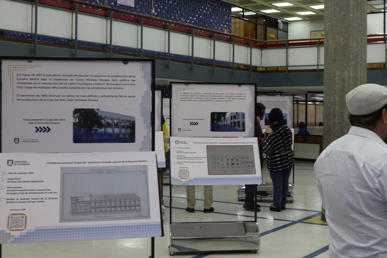 Visitantes recorren el Hall de Biblioteca Central UdeC entre paneles con imágenes de Mapas y Planos patrimoniales del campus UdeC