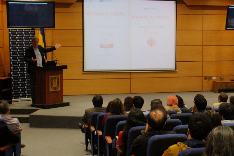 El Premio Nacional de Historia 2022, Dr. Rafael Sagredo, expone frente a un auditorio que escucha su exposición en auditorio de la Universidad de Concepción.