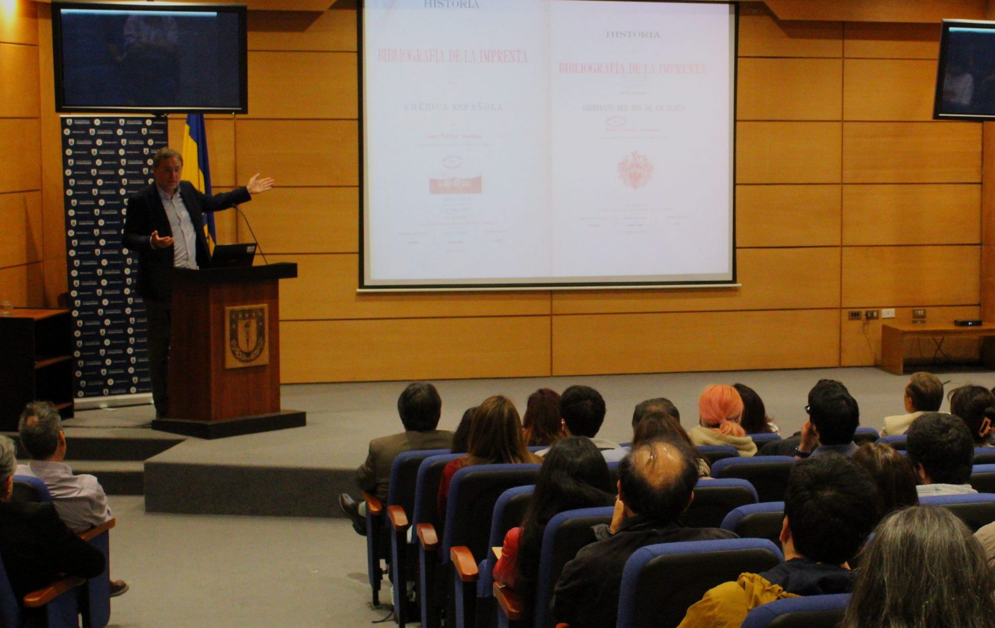 El Premio Nacional de Historia 2022, Dr. Rafael Sagredo, expone frente a un auditorio que escucha su exposición en auditorio de la Universidad de Concepción.