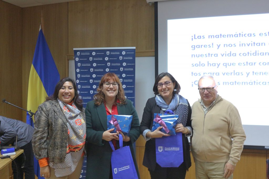 Expositoras reciben regalo del Decano de Ciencias Físicas y Matemáticas, Dr. Roberto Riquelme Sepúlveda y la Directora de Bibliotecas, Karen Jara Maricic.