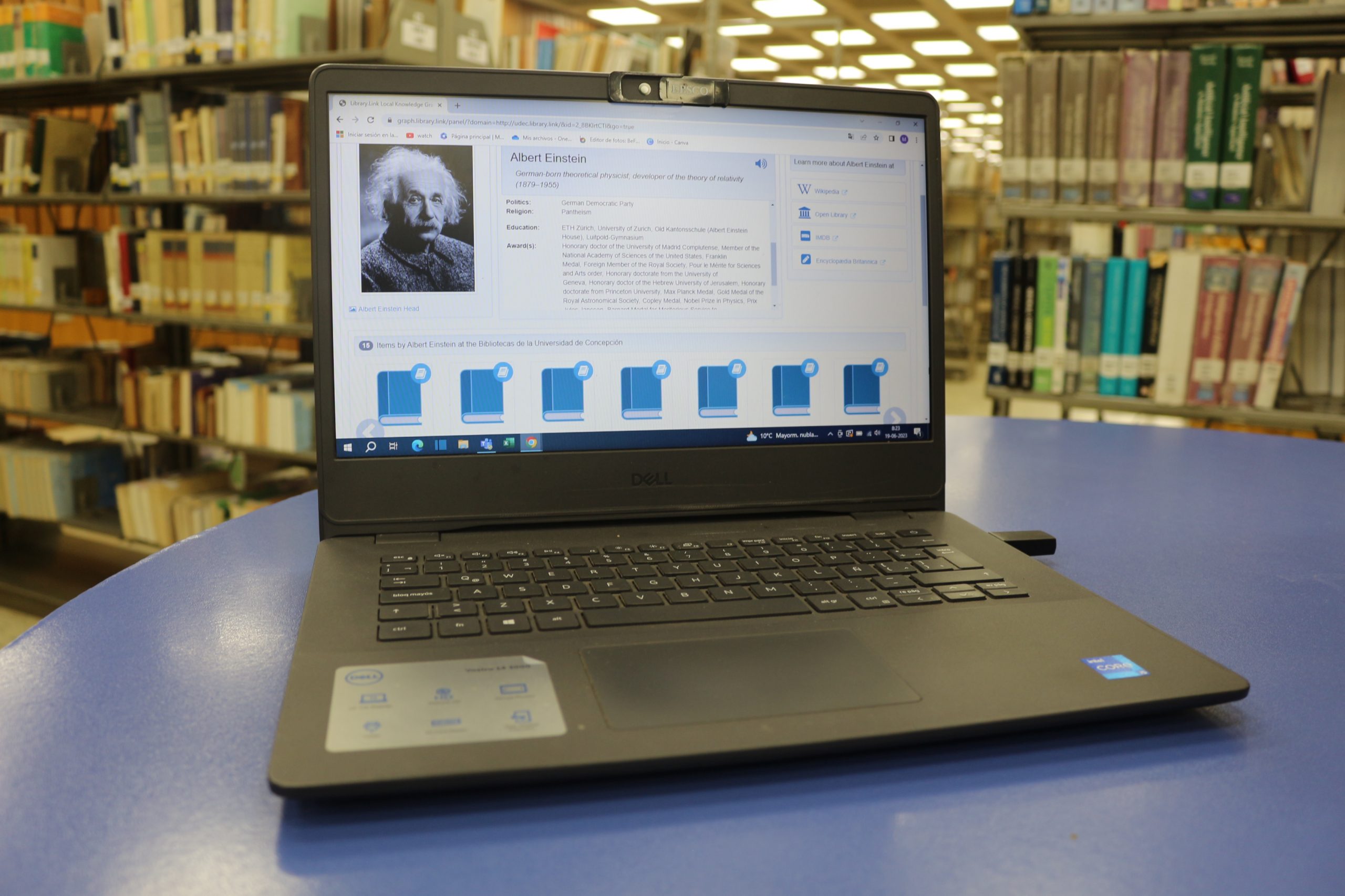 Laptop situada en mesa de consultad al medio de colección del tercer piso de la Biblioteca Central