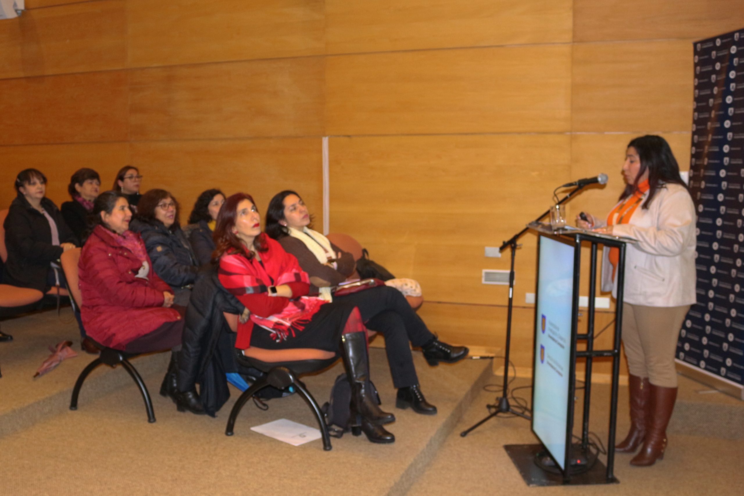 La Directora de Bibliotecas UdeC, Karen Jara Maricic, habla desde un podio a las y los asistentes durante lanzamiento de nuevos repositorios
