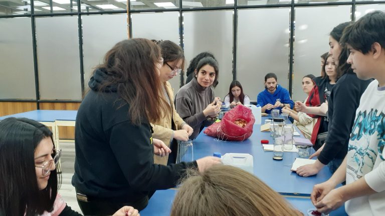Estudiantes escuchan a Violeta Rebolledo, quien dicta taller sobre acuarela botánica