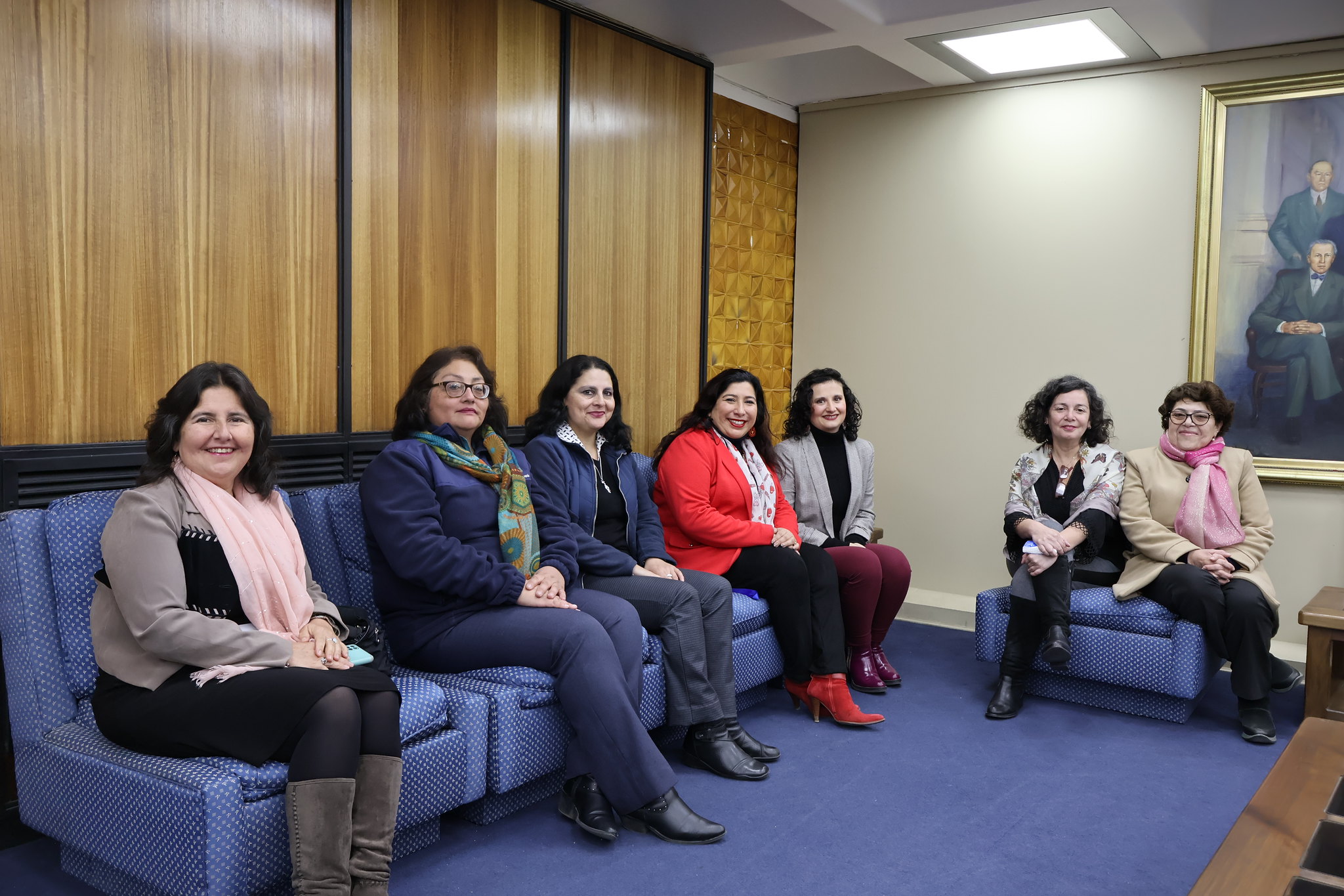 Imagen grupal de trabajadoras homenajeadas por sus 25 y 30 años de servicio en Bibliotecas UdeC junto a Directora Karen Jara Maricic durante actividad en entrada al Salón Azul del Edificio Central