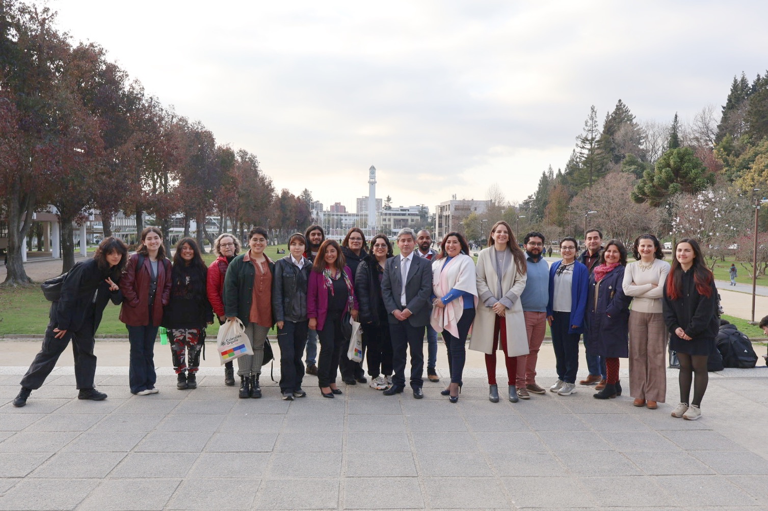 Foto grupal de premiados en primer concurso de Poesía Disidente junto a autoridades UdeC con el Campanil al fondo