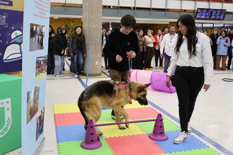 Estudiante acompaña a perro en acrobacias realizadas en Hall de Biblioteca Central