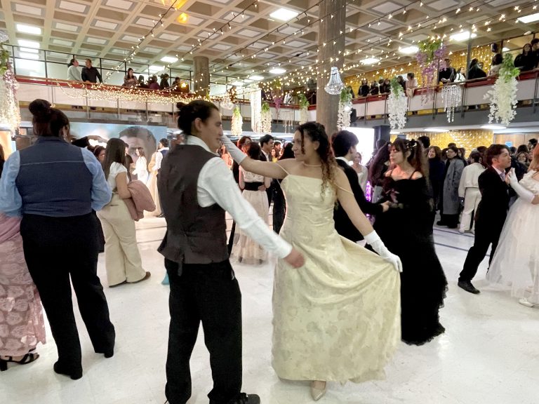 Parejas bailan vals con trajes de época en hall de edificio Central de Bibliotecas UdeC