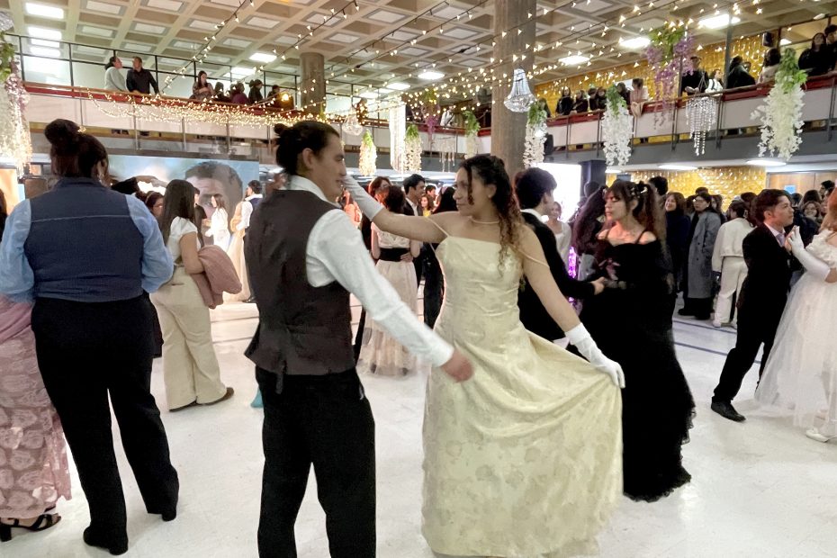 Parejas bailan vals con trajes de época en hall de edificio Central de Bibliotecas UdeC