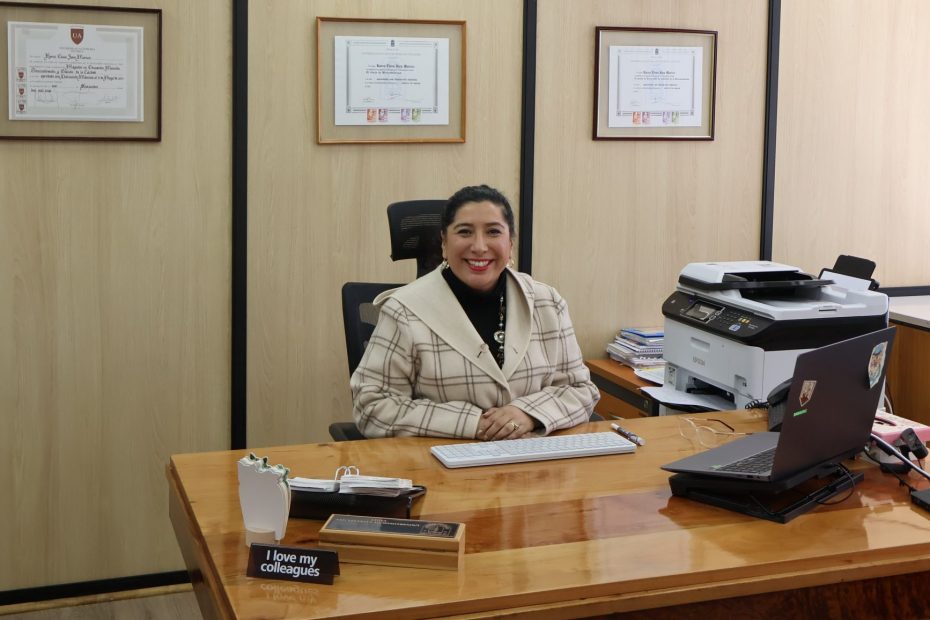 Foto que muestra a la Directora de Bibliotecas UdeC, Karen Jara Maricic, en su escritorio