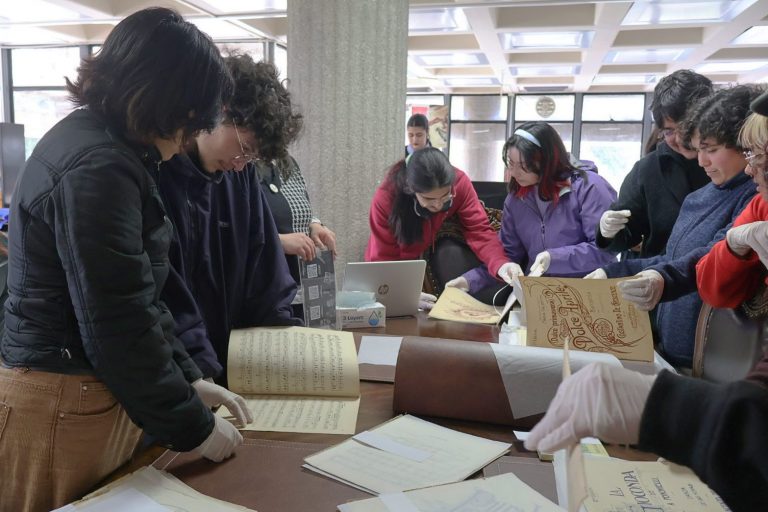 Estudiantes revisan partituras en mesón ubicado en Sala Chile de Bibliotecas UdeC
