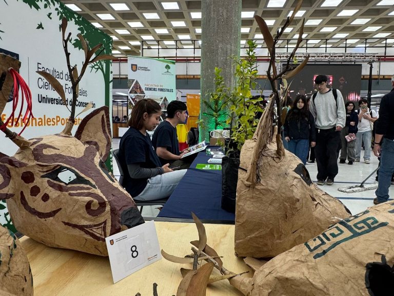 Monitores atienden dudas de estudiantes en stand ubicado en Biblioteca Central durante feria "De la Raíz al Papel"