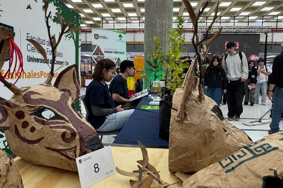 Monitores atienden dudas de estudiantes en stand ubicado en Biblioteca Central durante feria "De la Raíz al Papel"