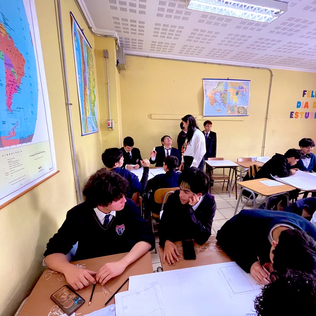 Estudiantes realizan carpetas para guardar archivos mientras integrante de equipo de Sala Chile entrega instrucciones