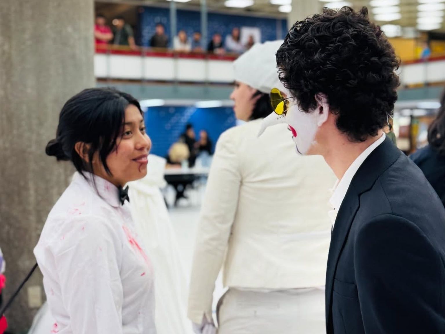 Estudiantes disfrazados conversan en hall de la Biblioteca Central