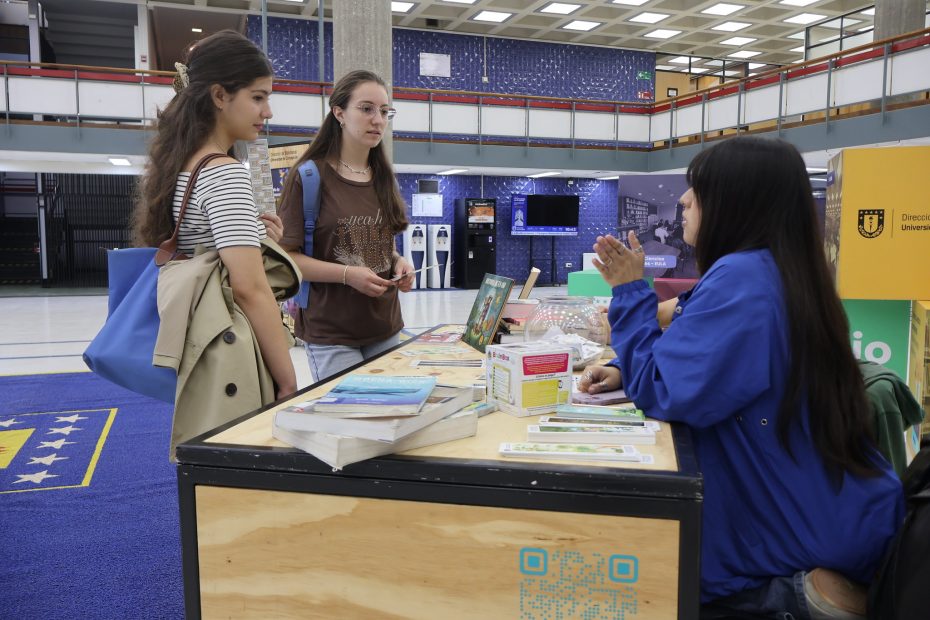 Estudiantes consultan stand informativo en Biblioteca Central