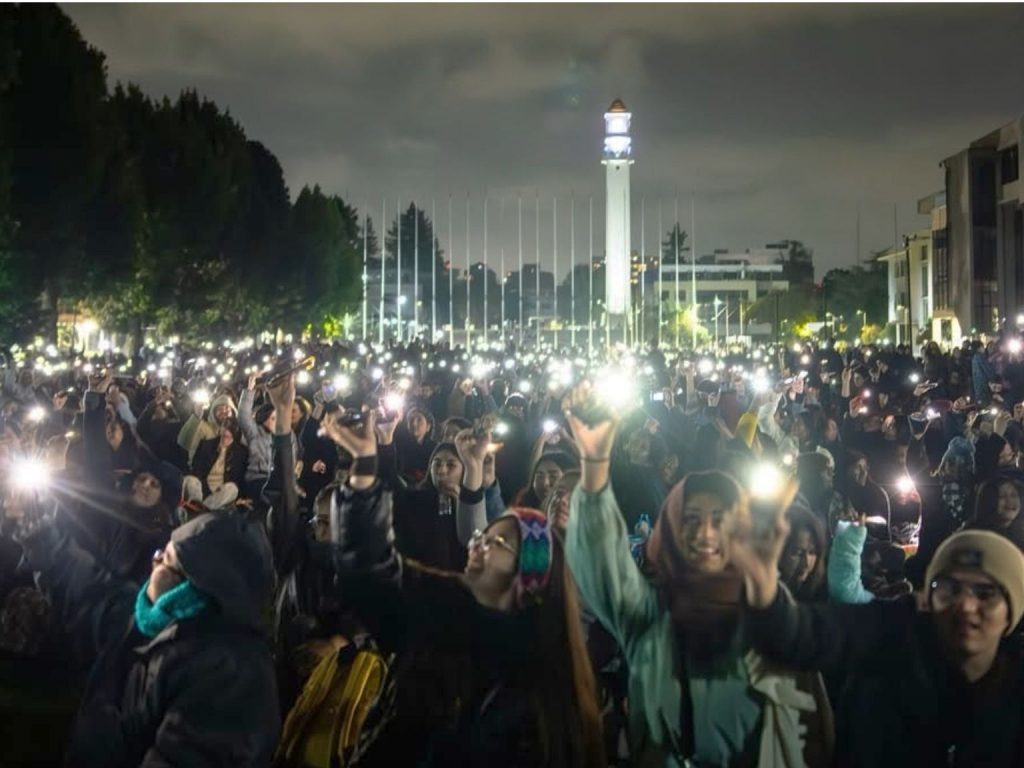 Asistentes a videomapping encienden linternas de sus celulares con el Campanil UdeC de fondo