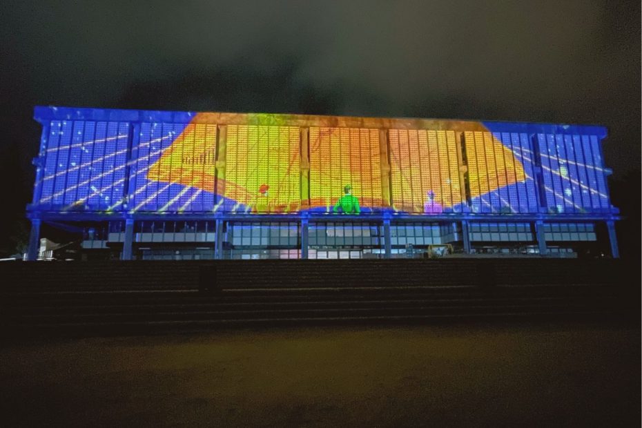 Una serie de figuras son proyectadas en la fachada de la Biblioteca Central UdeC durante videomapping