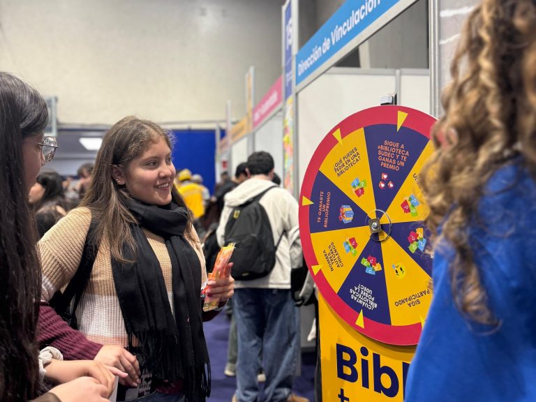 Estudiantes juegan con ruleta en stand instalado en uno de los gimnasios de la Casa del Deporte