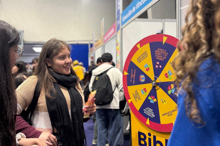 Estudiantes juegan con ruleta en stand instalado en uno de los gimnasios de la Casa del Deporte