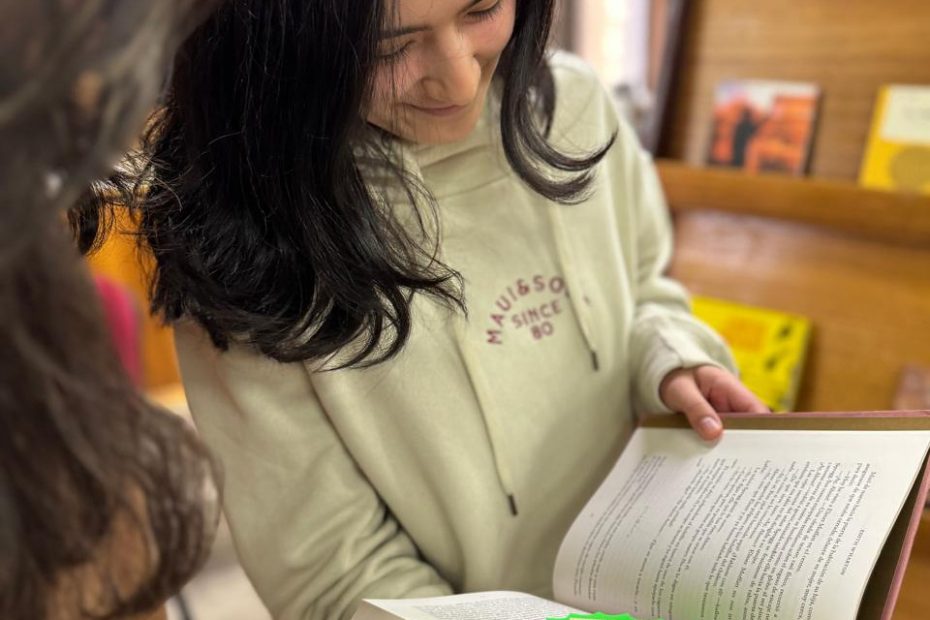 Estudiante hojea libro durante actividad de intercambio realizada en la Biblioteca Central UdeC