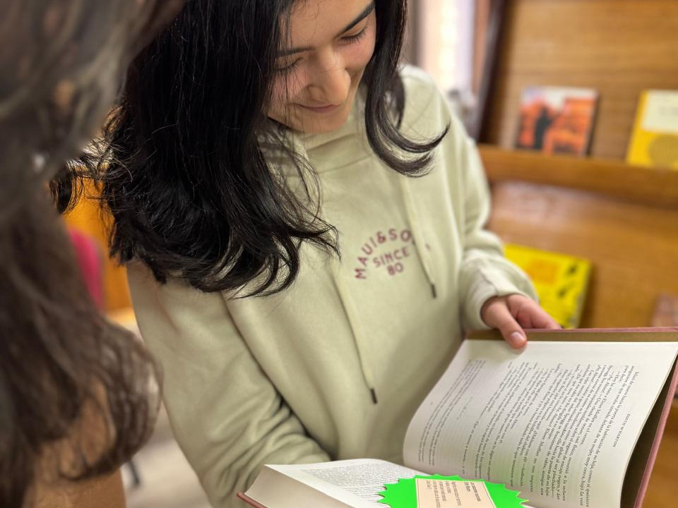 Estudiante hojea libro durante actividad de intercambio realizada en la Biblioteca Central UdeC