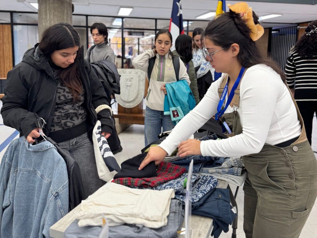Asistentes a Feria Circular UdeC revisan ropa dirante intercambio efectuado en hall de Biblioteca Central