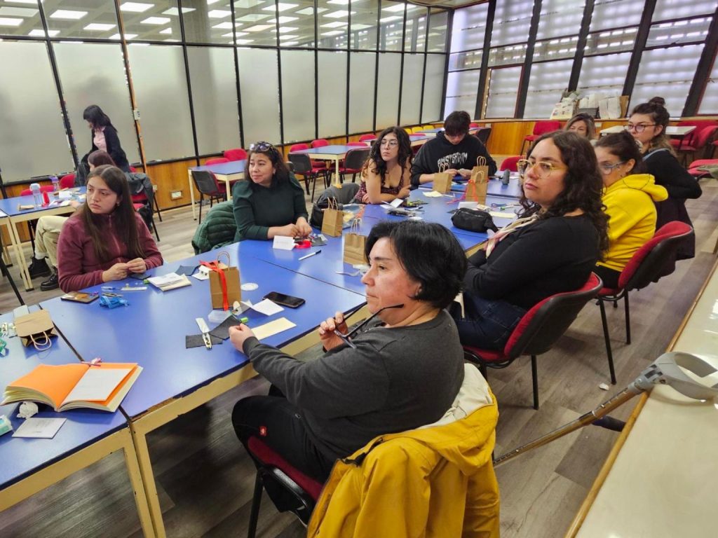 Asistentes a taller efectuado en Biblioteca Central sobre técnicas de zurcido escuchan instrucciones de monitora