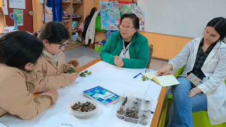 Imagen de archivo que muestra a monitora de taller junto a estudiantes