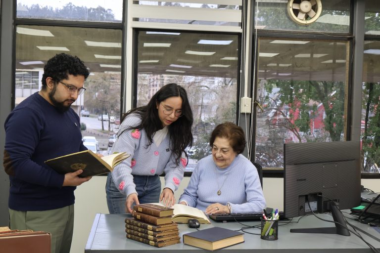 Equipo de Bibliotecas UdeC revisa una serie de libros en una de las salas de la Biblioteca Central