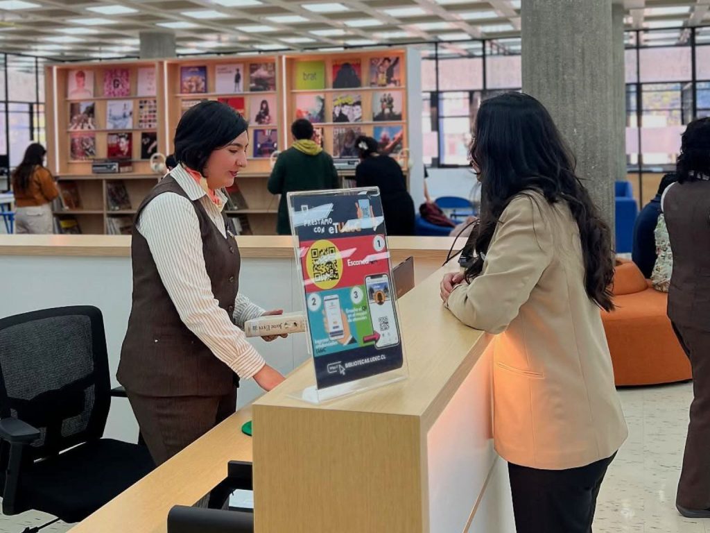 Bibliotecaria atiende a estudiante en el cuarto piso de la Biblioteca Central