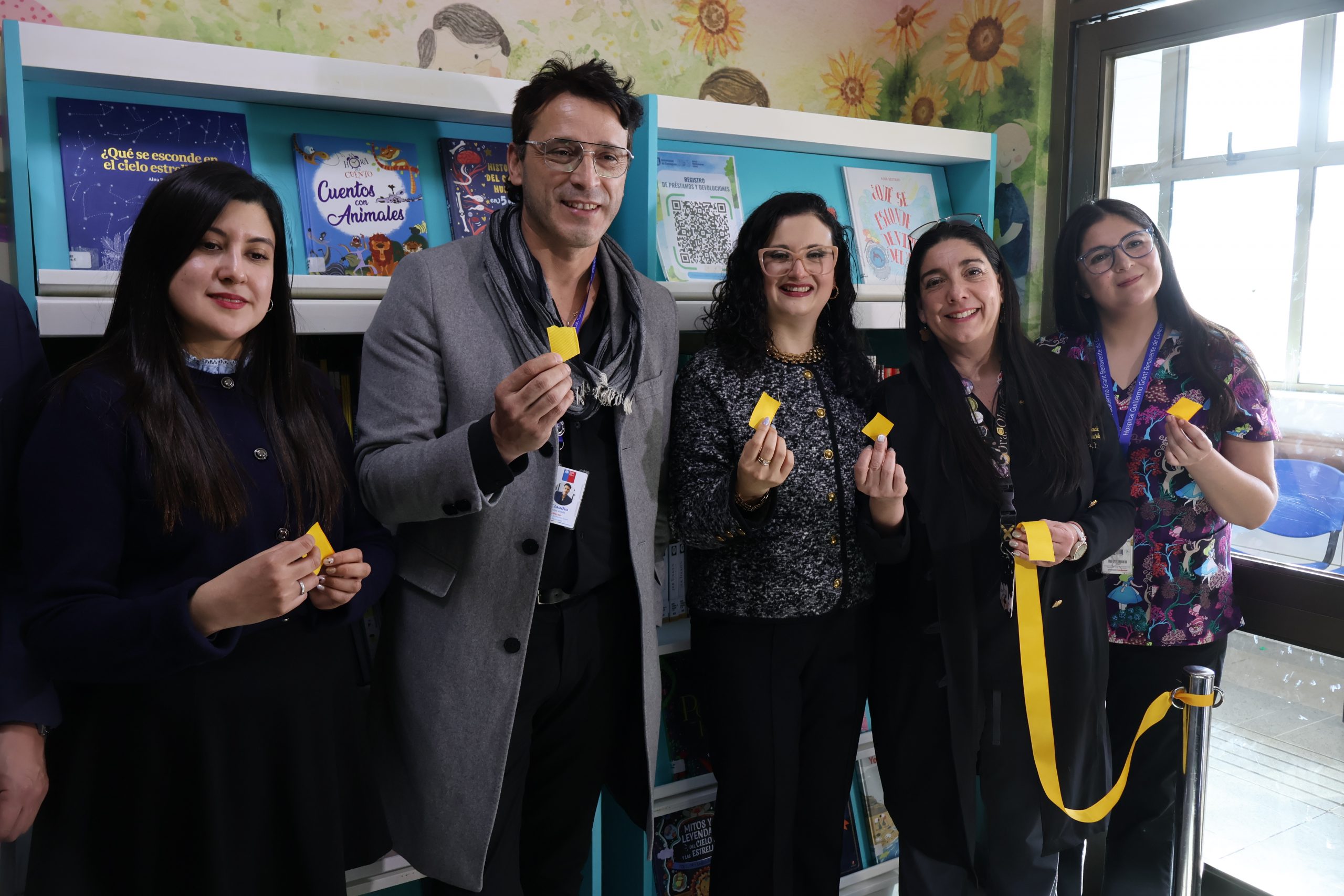 Fotografía grupal de autoridades durante corte de cinta que inauguró colección de libros en Servicio de Oncopediatría