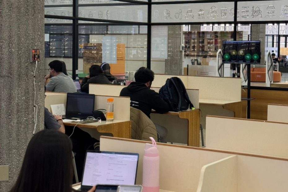 Un grupo de estudiantes ocupa una de las salas del cuarto piso de la Biblioteca Central, al fondo se ve el monitor que indica la medición del semáforo ambiental
