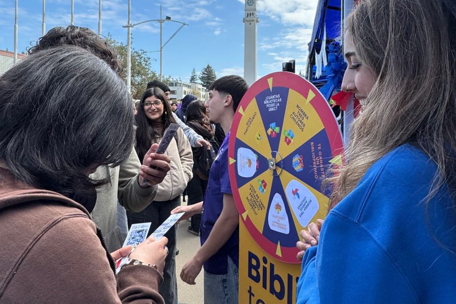 Estudiantes juegan a la ruleta en stand de Bibliotecas UdeC