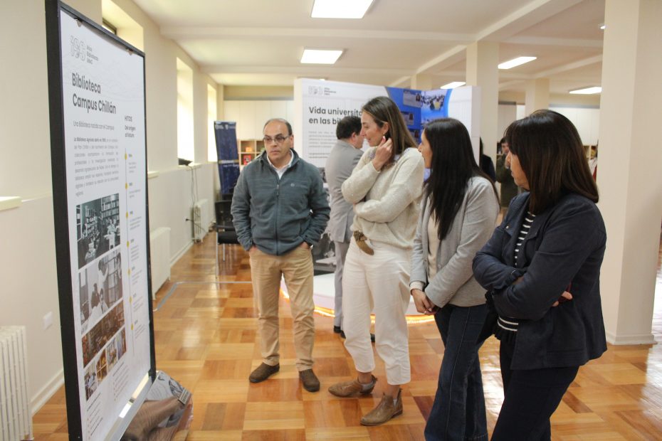 Asistentes observan paneles en el segundo piso de la Biblioteca del Campus Chillán